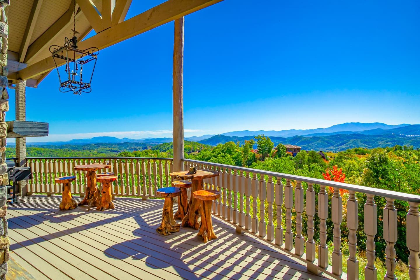 Stools at the rail, blue sky and layer after layer of mountains. You may never want to go inside, and nobody will blame you.
