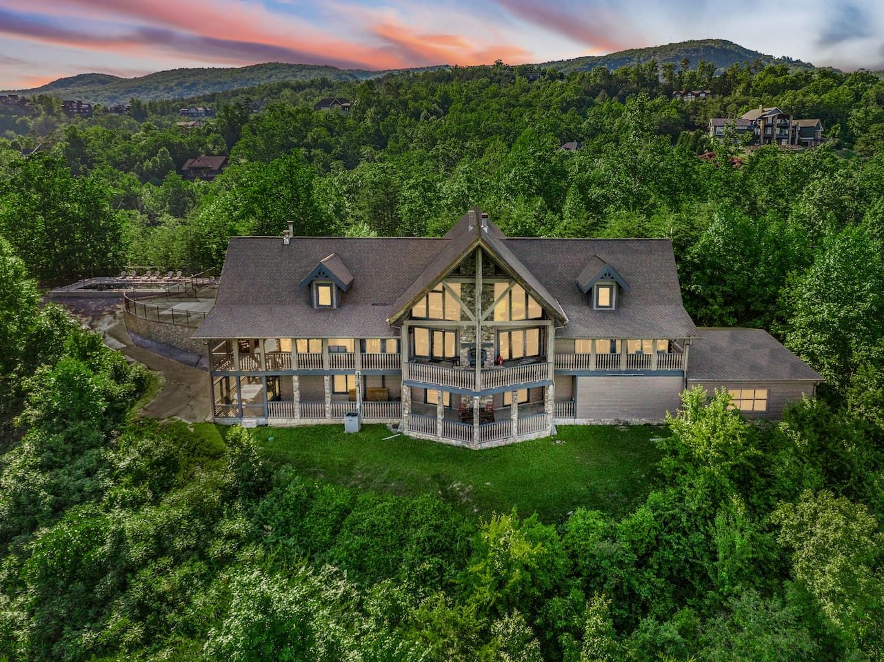 Golden hour on Majestica: windows aglow, forest all around, the Smokies stretching behind. Home sweet mountaintop home.