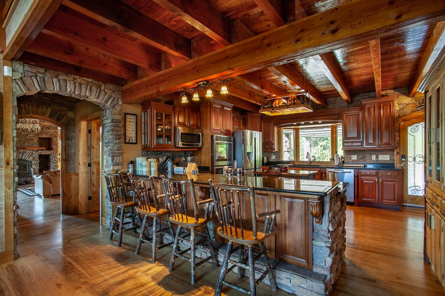 Coffee at the island, stories at the bar stools. This warm wood-and-stone kitchen is where breakfasts turn into laughter that lasts all morning.
