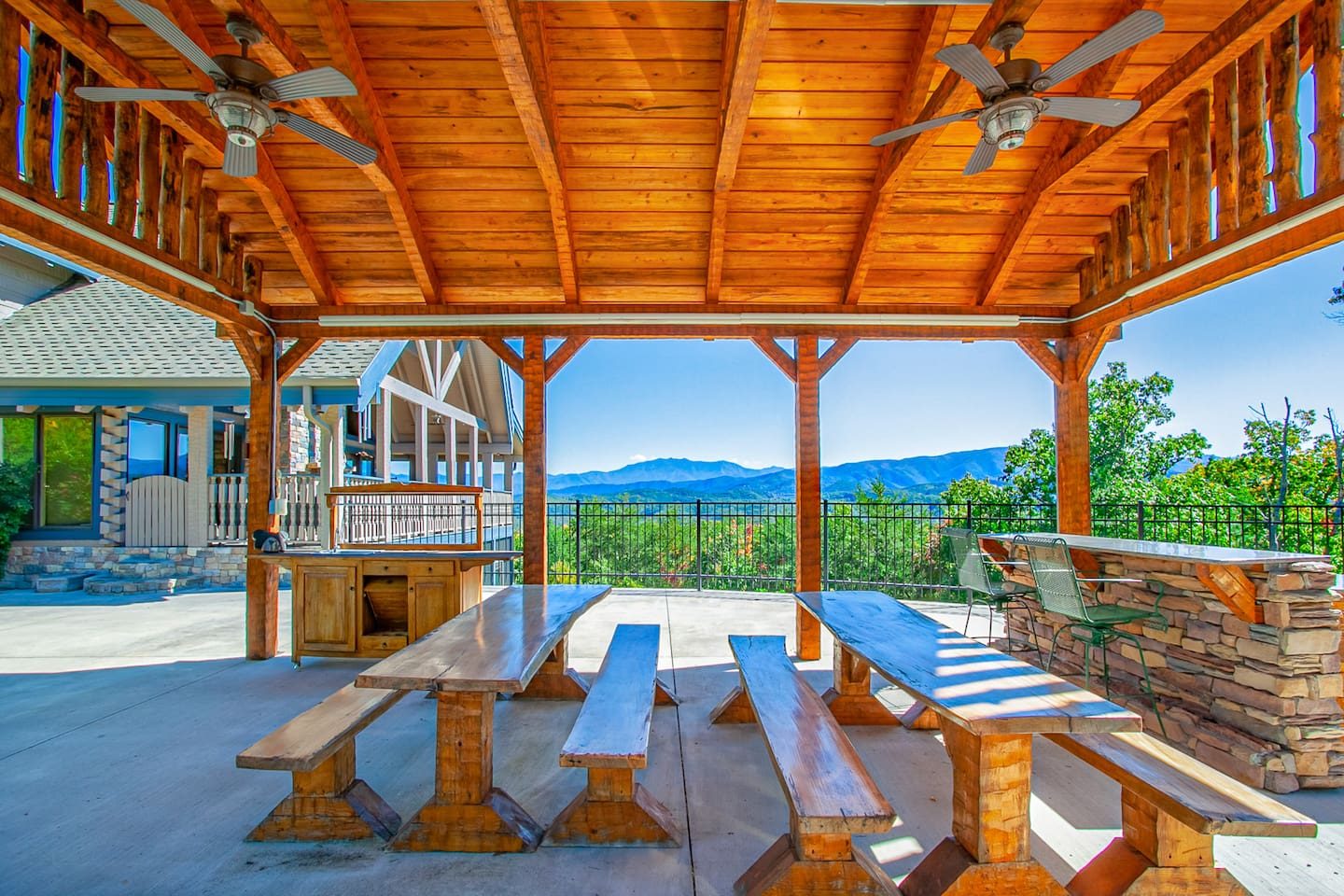 A timber pavilion with long picnic tables, an outdoor bar and a Smoky Mountain backdrop. Feast outside and let the evening stretch on.