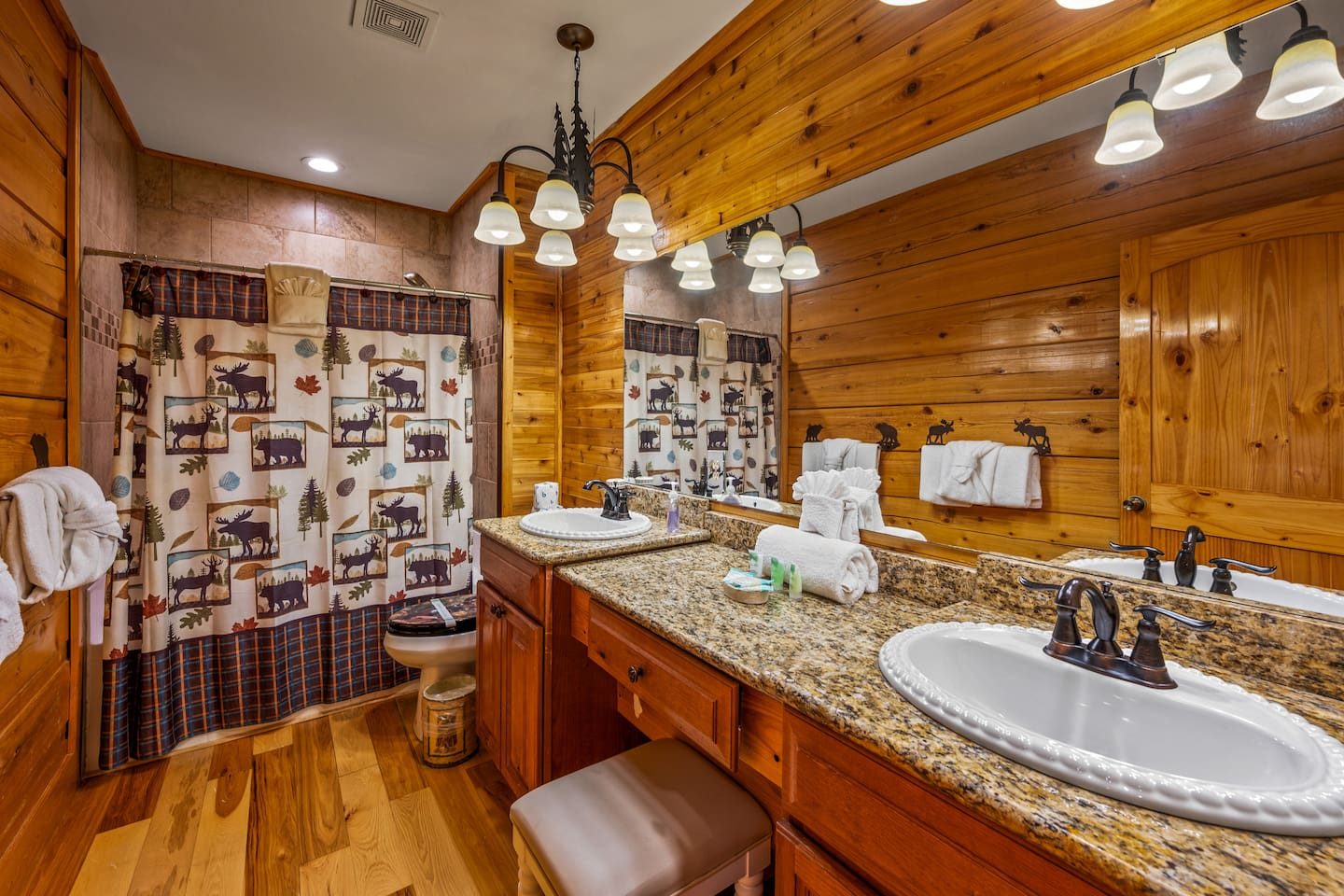 A long granite vanity, a woodland-print shower curtain and a handy stool make busy mornings easy. Everyone gets room to get ready.