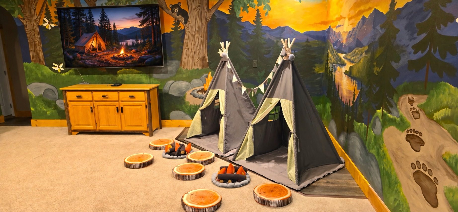 Welcome to the Bigfoot Bunk Room, where tents, a mural forest and a campfire glow turn bedtime into a wilderness adventure the kids will beg for.