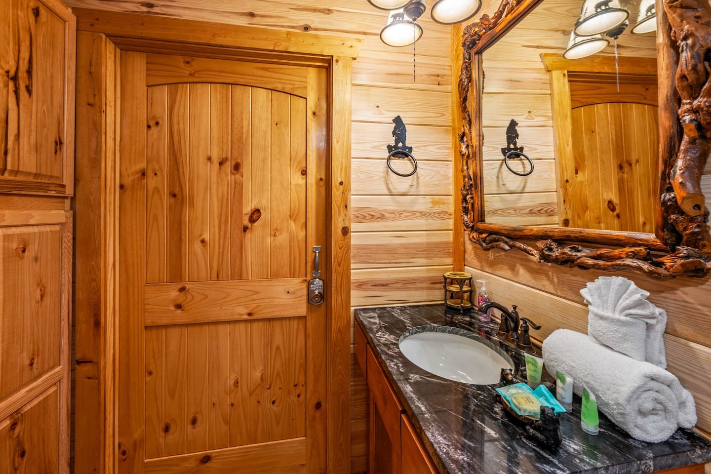 Knotty pine, a live-edge mirror and fluffy rolled towels. Little touches that make every bathroom feel like a cabin spa.