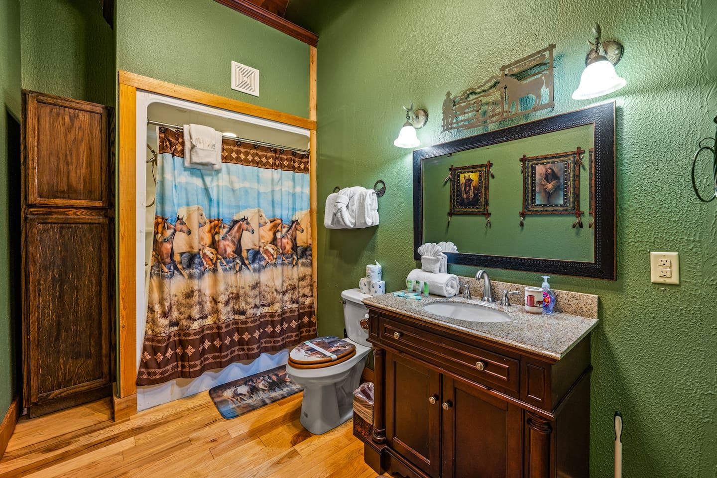 Green walls, galloping horses on the curtain and a handsome wood vanity. A bright little bath with a whole lot of personality.