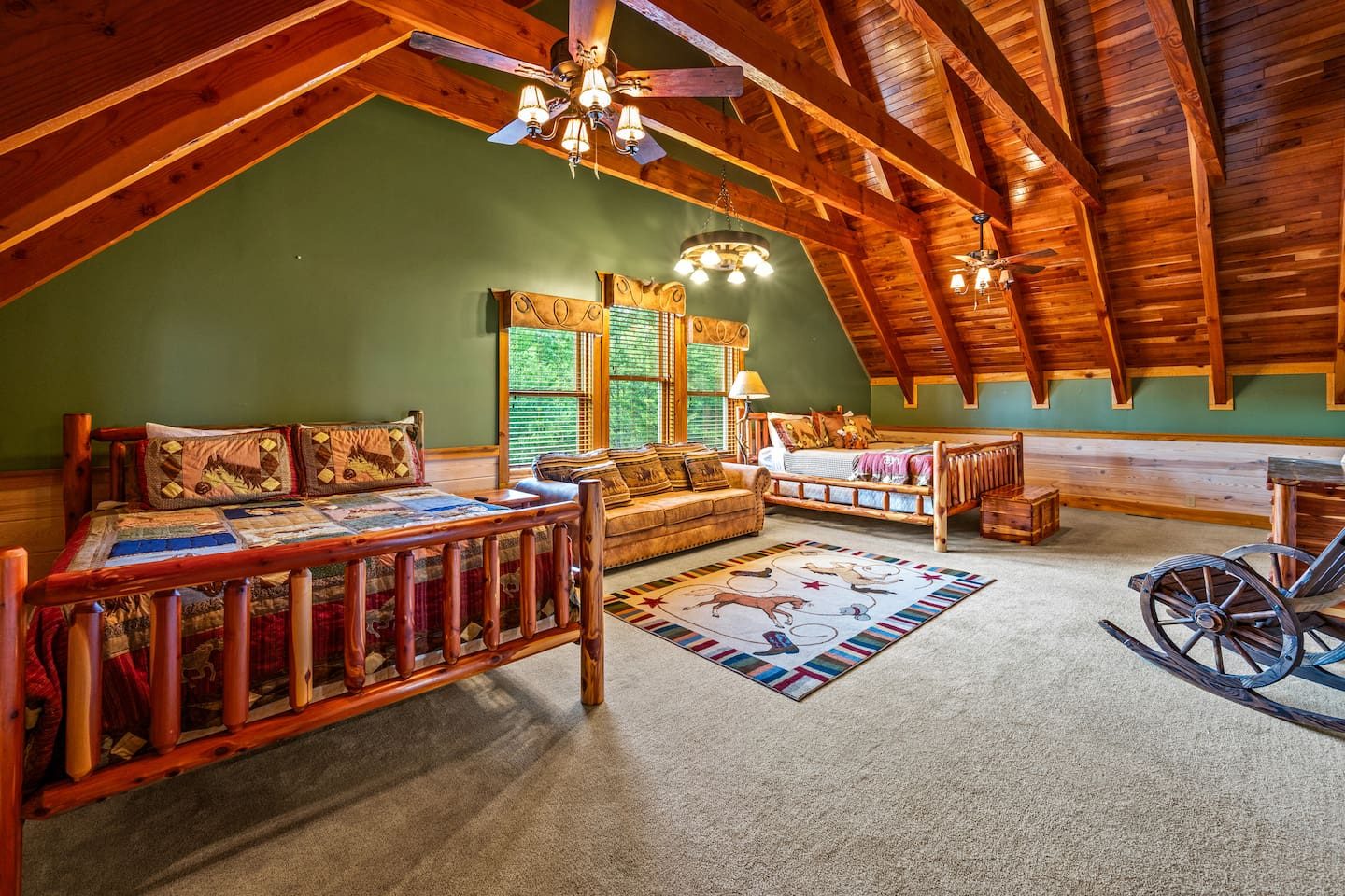 Beneath a soaring timber ceiling, log beds and a snug seating area make the loft bedroom a cozy hideaway for kids, cousins and the young at heart.
