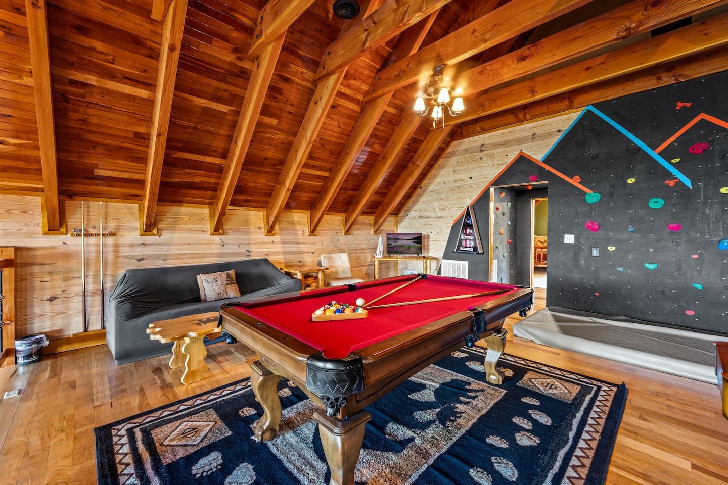 Pool table, climbing wall and plush seating under cathedral beams. Settle into the loft and make it a game night to remember.